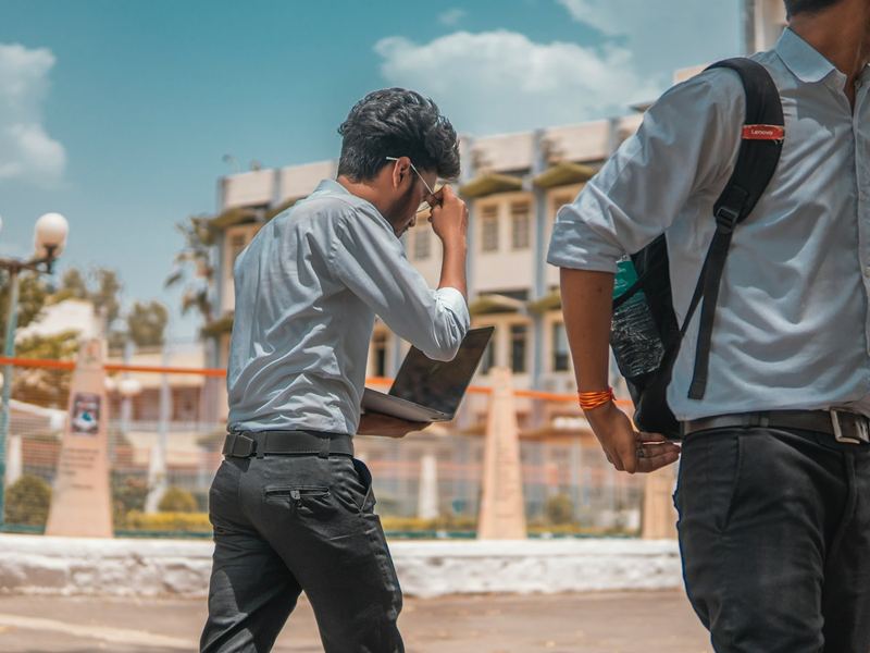 Two students with backpacks walking on campus