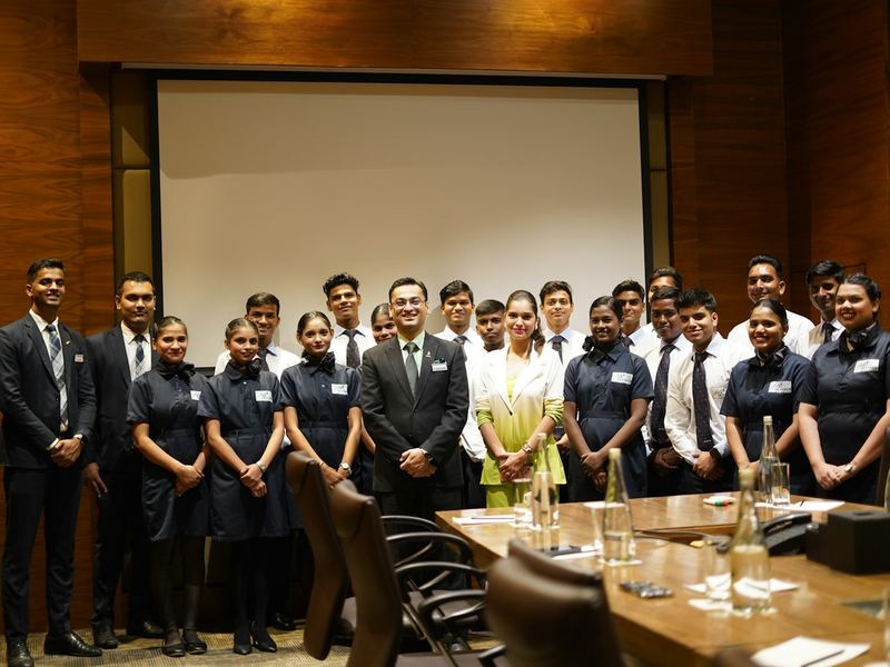 A batch of trainees in formal clothes posing together after a certification event