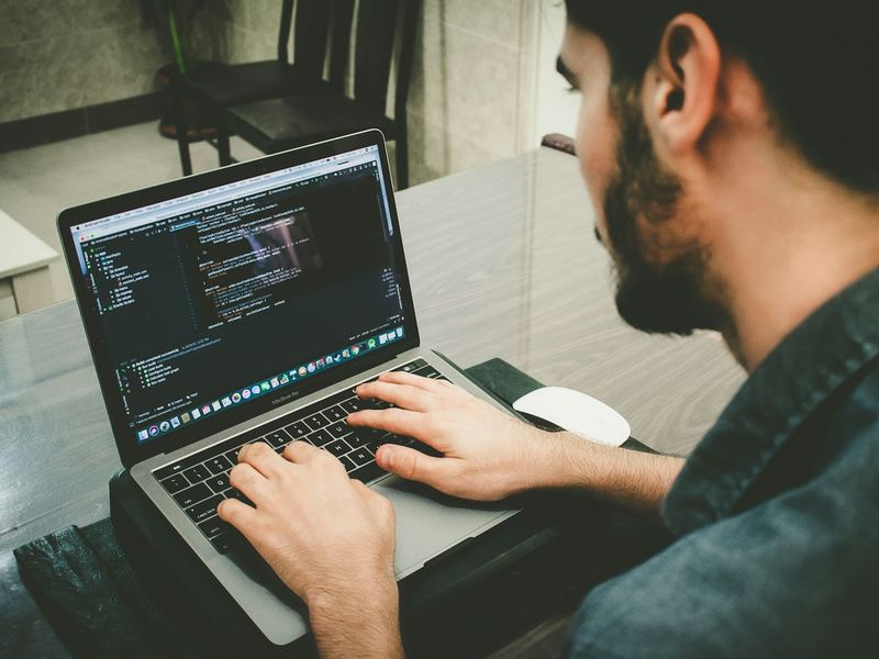 Hands typing code on a laptop